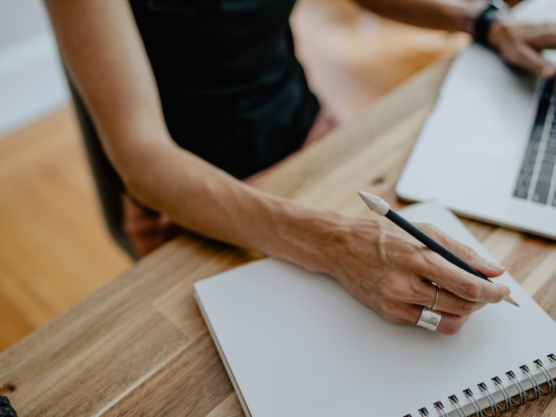 a person writing on a piece of paper